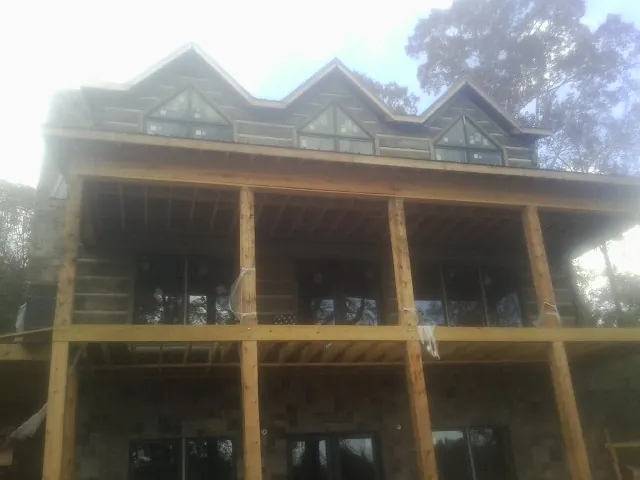 Dormers and porch framing on a large log home under construction — Roof Coating work by our crew in Richmondville