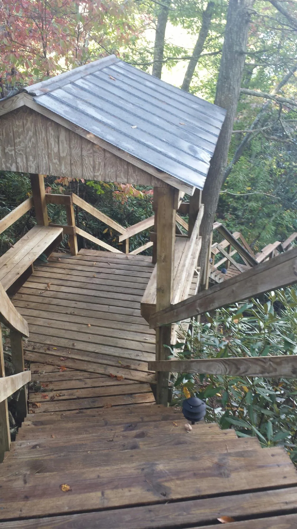 Metal roofed shelter over wooden steps on a wooded walkway — Skylight Repair & Installation work by our crew in Richmondville
