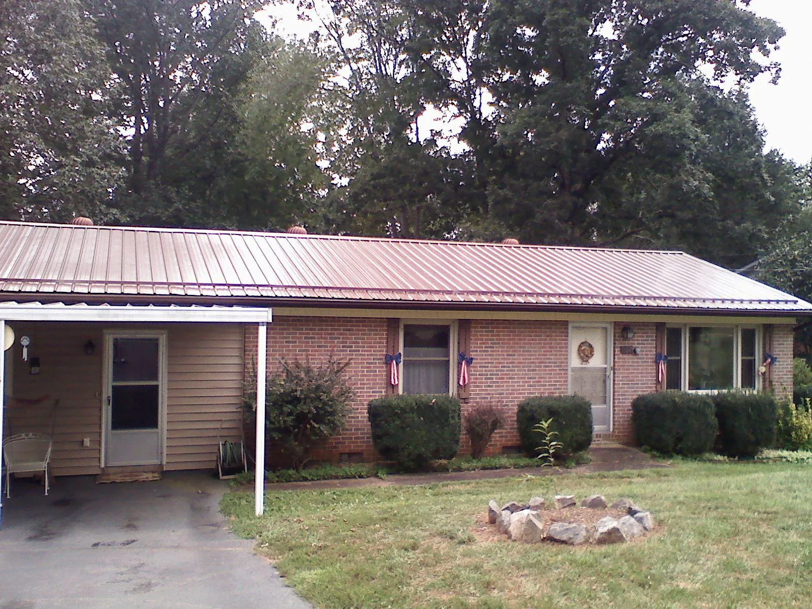 Bronze metal roof and carport on a brick ranch home — Roof Repair work by our crew in Richmondville
